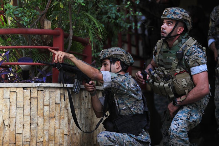 Detik-detik Bentrokan Bersenjata di Beirut Warga berhamburan menyelamatkan diri saat terjadi bentrokan bersenjata di Ibu Kota Beirut, Lebanon. Tembakan dari atap gedung itu menyasar ke kelompok demonstran Syiah. (AP Photo/Hassan Ammar)