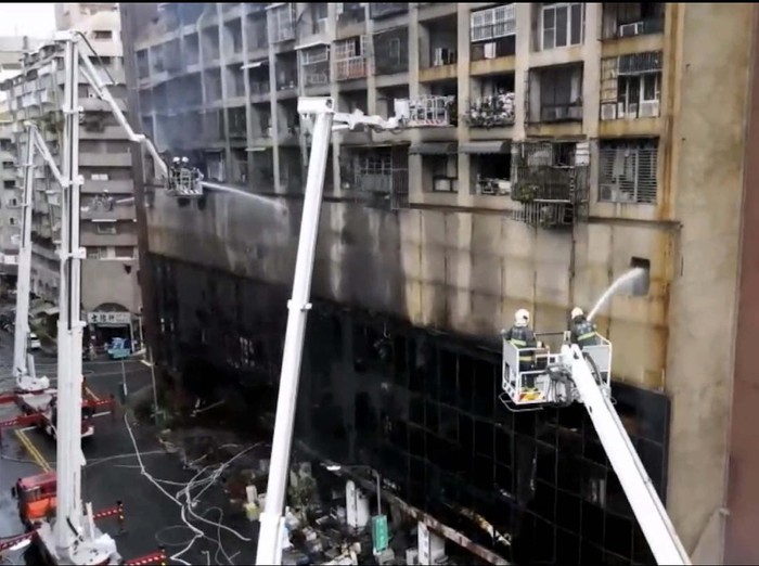 In this image taken from video by Taiwans EBC, firefighters shoot water into a building that caught fire in Kaohsiung, in southern Taiwan on Thursday, Oct. 14, 2021. The fire engulfed a 13-story building overnight in southern Taiwan, the islands semi-official Central News Agency reported Thursday. (EBC via AP )