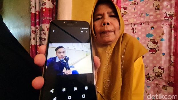 Keluarga Memperlihatkan Foto Bona