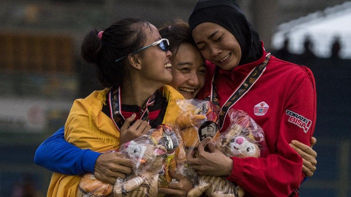 Atlet putri Bali Ni Made Eppi (kiri) bersama atlet putri Jawa Barat Ika Puspa Dewi (tengah) dan atlet putri DKI Jakarta Nadia Anggraini (kanan) berpelukan usai pengalungan medali Lompat Tinggi Putri PON Papua di Stadion Atletik Mimika Sport Centre, Kabupaten Mimika, Papua, Rabu (13/10/2021). Ni Made berhasil meraih medali emas, sementara atlet Jawa Barat Ika Puspa Dewi meraih medali perak dan atlet DKI Jakarta Nadia Anggraini meraih medali perunggu. ANTARA FOTO/Novrian Arbi/YU