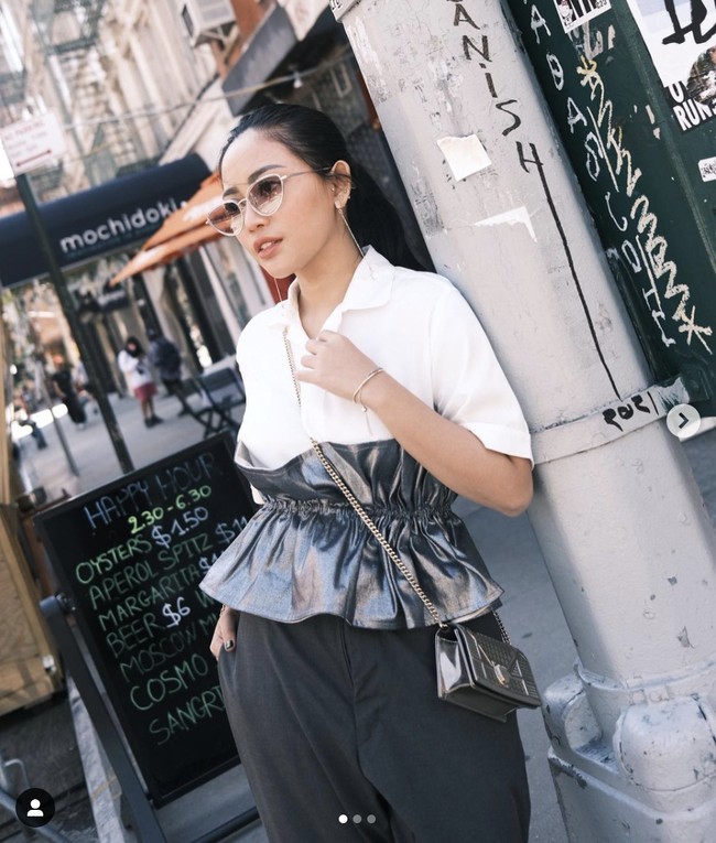 Mengenakan kemeja dari Erigo, Rachel Vennya memadukannya dengan brand high end saat bergaya di jalanan New York. Ibu dua anak itu tampak memakai tas dari Dior yang matching dengan atasan silvernya. Foto: Dok. Instagram @rachelvennya