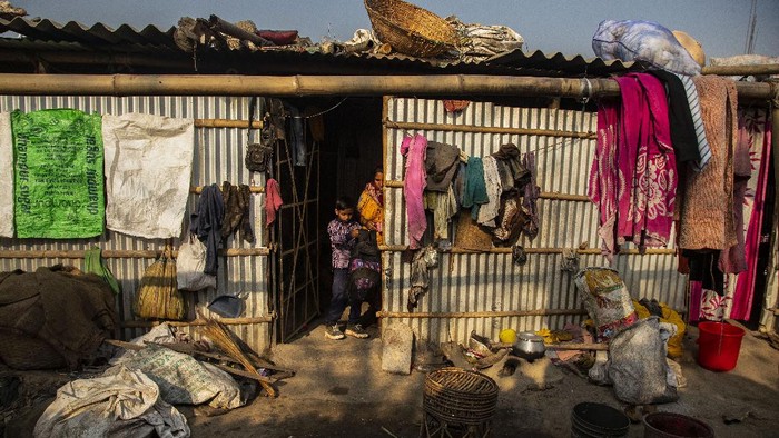Imradul Ali, 10, center, takes his school bag from his mother Anuwara Beghum, 30, as he leaves for school from his rented kitchen cum bedroom on the outskirts of Gauhati, India, Friday, Feb. 5, 2021. Once school is done for the day, Ali, rushes home to change out of his uniform so that he can start his job as a scavenger in India’s remote northeast. Coming from a family of scavengers or “rag pickers,