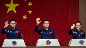 Astronot Tiongkok dari China Manned Space Agency, kanan ke kiri, Wang Yaping, Zhai Zhigang, dan Ye Guangfu melambai pada konferensi pers di Pusat Peluncuran Satelit Jiuquan, Jiuquan, China, Kamis (14/10) waktu setempat.  