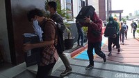 Mereka lalu diminta untuk masuk berbaris ke gedung sambil menggendong PC berwarna hitam.