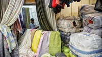Warga melintas di depan salah satu kios pakaian bekas di kawasan Pasar Senen.