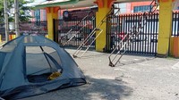 Gerbang ditutup dengan memasang besi penghalang. Ada juga tenda yang didirikan mahasiswa di dalam kampus. Sejumlah mahasiswa terlihat berada di dekat tenda itu. (Foto: Ahmad Arfah Fansuri Lubis/detikcom)