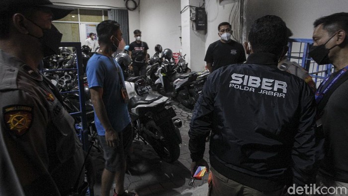 Detik-detik Polisi Gerebek Kantor Pinjol Ilegal di Yogyakarta Petugas Kepolisian berjaga di depan kantor saat penggerebekan dan penggeledahan lokasi kantor pinjaman online di Sleman, Yogyakarta, Kamis (14/10/2021).