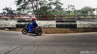 Pengendara sepeda motor melintas di Jalan Sholeh Iskandar Kota Bogor yang amblas.