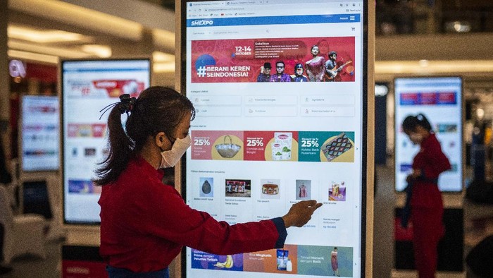 Pramuniaga berjalan di depan layar yang menamilkan laman SMEXPO Marketplace dalam pameran Pertamina SMEXPO 2021 di Fashion Atrium, Kota Kasablanka, Jakarta, Jumat (15/10/2021). Pameran virtual dan marketplace Pertamina SMEXPO 2021 yang berlangsung hingga 17 Oktober 2021 itu merupakan salah satu langkah Pertamina dalam mendukung Gerakan Nasional Bangga Buatan Indonesia dengan menampilkan produk-produk hasil dari UMKM mitra binaan di seluruh Indonesia. ANTARA FOTO/Aprillio Akbar/foc.
