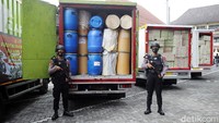 Petugas Kepolisian bersenjata menjaga sejumlah truk yang berisi barang bukti berupa obat keras ilegal hasil sitaan.