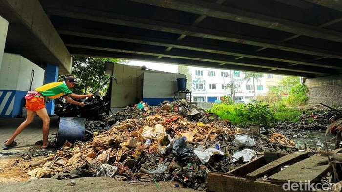 Sampah Menumpuk di Sungai Kolong Tol JORR Jati Warna Dibersihkan Antisipasi musim hujan dan banjir, sejumlah petugas dari Dinas Lingkungan Hidup Kecamatan Jati Melati, Kota Bekasi, Jumat (15/10/2021), mengangkut tumpukan sampah yang berada di aliran kali bawah Fly over Tol JORR Jati Warna.