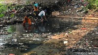 Sejumlah petugas menyusuri sungai untuk membersihkan sampah yang mengambang di aliran air.