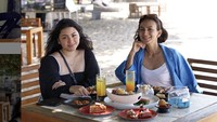 Begini momen santai Wanda saat makan bareng temannya di Bali. Segelas minuman segar menyempurnakan waktu senggang mereka di pinggir pantai.