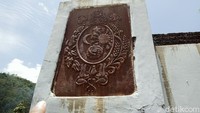 Tugu bercat putih yang mulai luntur. Pelat besi simbol Kasunanan Surakarta berukir Radya Laksana yang tertempel di tembok terlihat kusam dan berkarat.
