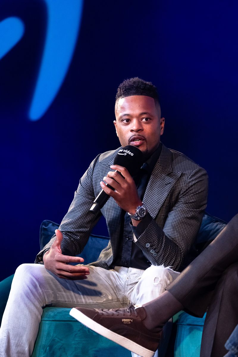LONDON, ENGLAND - OCTOBER 12: Patrice Evra speaking with Gabby Logan on stage at the 'Prime Video Presents Sport' event at Pan Pacific on October 12, 2021 in London, England.  At the event a series of announcements were revealed, including the Amazon Original documentary on the life and career of Wayne Rooney and Lioness: The Nicola Adams Story.  (Photo by Tim P. Whitby/Getty Images for Amazon Prime)