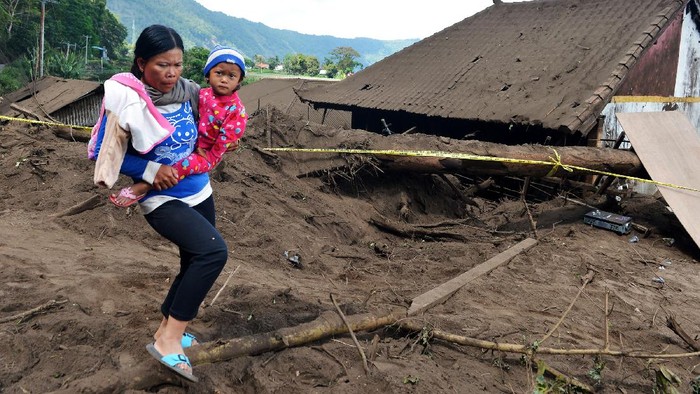Rumah dan Mobil Tertimbun Longsor Akibat Gempa di Bali Warga berjalan di dekat rumah yang rusak tertimbun longsoran bukit akibat gempa di kawasan Trunyan, Kintamani, Bangli, Bali, Sabtu (16/10/2021). Gempa bumi dengan magnitudo 4,8 SR yang terjadi di darat pada jarak delapan kilometer barat laut Karangasem dengan kedalaman 10 km pada Sabtu (16/10) pukul 04.18 Wita mengakibatkan sejumlah bangunan di Bali rusak dan tiga orang meninggal dunia. ANTARA FOTO/Fikri Yusuf/hp.