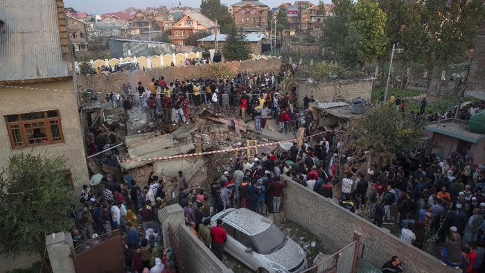 Unidentified villagers wail near the house destroyed in a gunfight in Pampore, south of Srinagar, Indian controlled Kashmir, Saturday, Oct. 16, 2021. Indian government forces killed five rebels in last 24-hours in disputed Kashmir on Saturday, officials said, as violence increased in recent weeks. (AP Photo/Dar Yasin)