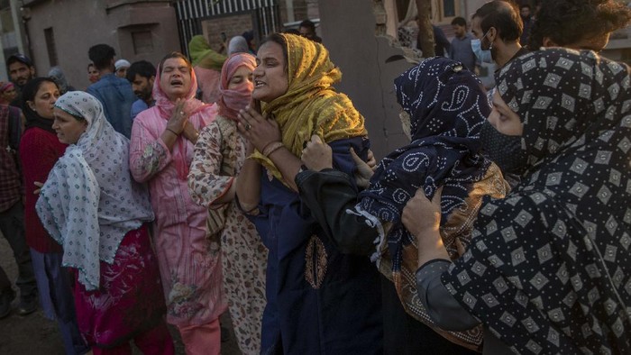 Unidentified villagers wail near the house destroyed in a gunfight in Pampore, south of Srinagar, Indian controlled Kashmir, Saturday, Oct. 16, 2021. Indian government forces killed five rebels in last 24-hours in disputed Kashmir on Saturday, officials said, as violence increased in recent weeks. (AP Photo/Dar Yasin)