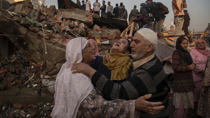 Derita Warga Sipil Korban Konflik di Kashmir Unidentified villagers wail near the house destroyed in a gunfight in Pampore, south of Srinagar, Indian controlled Kashmir, Saturday, Oct. 16, 2021. Indian government forces killed five rebels in last 24-hours in disputed Kashmir on Saturday, officials said, as violence increased in recent weeks. (AP Photo/Dar Yasin)