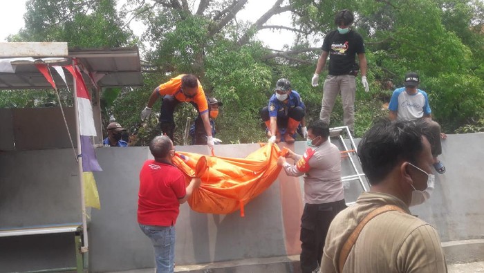 Petugas mengevakuasi mayat wanita berdaster merah yang ditemukan di Kali Angke, Kota Tangerang, Minggu (17/10/2021).