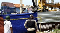 Tampak warga berusaha melihat crane yang roboh.