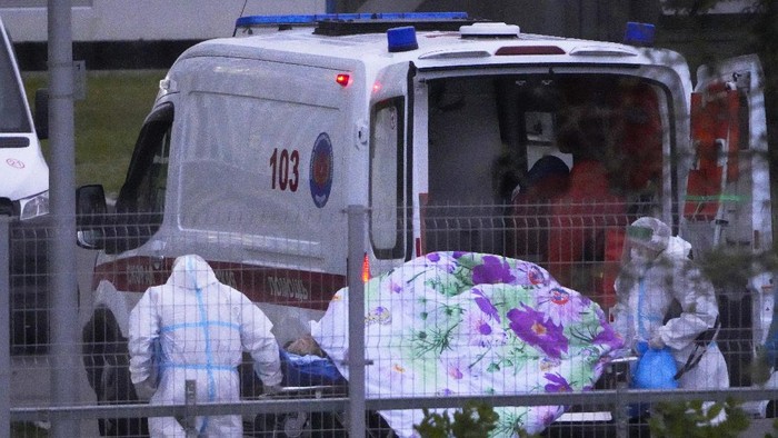 Rekor! Rusia Laporkan 34.303 Kasus Corona dalam Sehari Medical workers carry a patient suspected of having coronavirus on a stretcher at a hospital in Kommunarka, outside Moscow, Russia, Saturday, Oct. 16, 2021. Russias daily death toll from COVID-19 has exceeded 1000 for the first time as the country faces a sustained wave of rising infections. (AP Photo/Alexander Zemlianichenko)