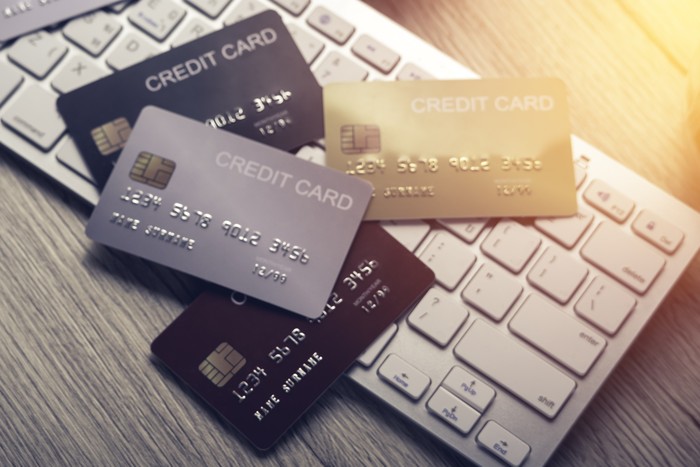 1253222991 many mockup credit card above white tablet keyboard on an office wooden table top view