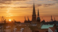 Menikmati senja di Aarhus dengan latar Katedral Aarhus Cathedral dan Gereja Our Lady. (Getty Images/Caroline Brundle Bugge)
