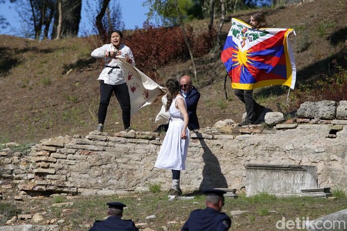 Petugas mengamankan aktivis yang mengibarkan bendera Tibet di Athena, Yunani. Aksi tersebut bertepatan dengan prosesi api Olimpiade Musim Dingin 2022.