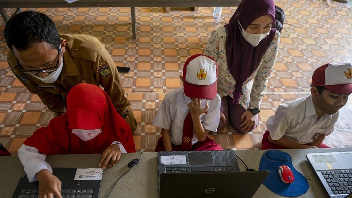 Sejumlah murid dibimbing gurunya mengikuti Asesmen Nasional Berbasis Komputer (ANBK) di sekolah darurat bencana SD Inpres Balaroa, Palu, Sulawesi Tengah, Senin (18/10). Meskipun dalam kondisi yang sangat terbatas, namun sekolah tersebut tetap melaksanakan ANBK yang bertujuan untuk mengukur kualitas kegiatan-belajar mengajar di sekolah. ANTARA FOTO/Basri Marzuki/hp.