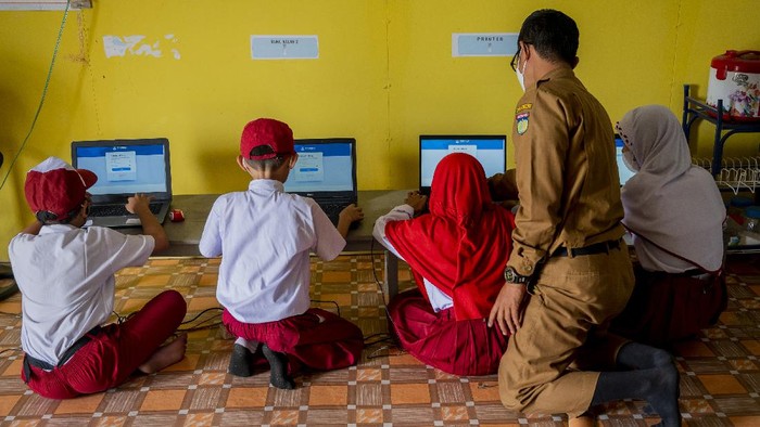 Sejumlah murid dibimbing gurunya mengikuti Asesmen Nasional Berbasis Komputer (ANBK) di sekolah darurat bencana SD Inpres Balaroa, Palu, Sulawesi Tengah, Senin (18/10). Meskipun dalam kondisi yang sangat terbatas, namun sekolah tersebut tetap melaksanakan ANBK yang bertujuan untuk mengukur kualitas kegiatan-belajar mengajar di sekolah. ANTARA FOTO/Basri Marzuki/hp.
