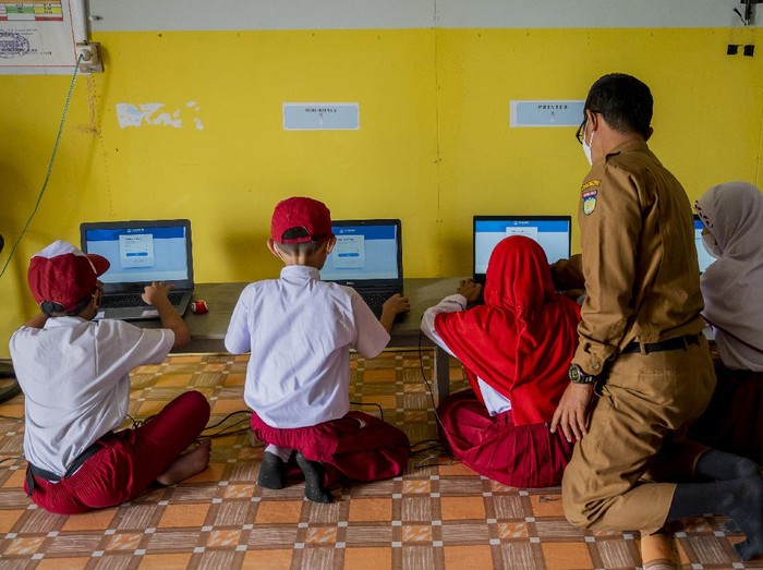 Sejumlah murid dibimbing gurunya mengikuti Asesmen Nasional Berbasis Komputer (ANBK) di sekolah darurat bencana SD Inpres Balaroa, Palu, Sulawesi Tengah, Senin (18/10). Meskipun dalam kondisi yang sangat terbatas, namun sekolah tersebut tetap melaksanakan ANBK yang bertujuan untuk mengukur kualitas kegiatan-belajar mengajar di sekolah. ANTARA FOTO/Basri Marzuki/hp.