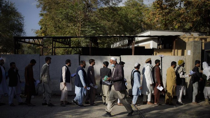 Warga mengantri untuk memperoleh layanan pembuatan paspor di Kabul, Afghanistan. Layanan yang dibuka sejak awal Oktober lalu dijaga ketat oleh tentara bersenjata.