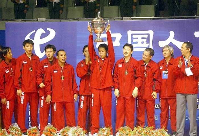 Indonesias badminton team celebrate with the Thomas Cup after beating Malaysia in the Thomas Cup mens team badminton final in the southern Chinese city of Guangzhou 19 May 2002. Indonesia beat Malaysia 3-2 to defend the title as the world best mens badminton team . AFP PHOTO/GOH Chai Hin (Photo by AFP)
