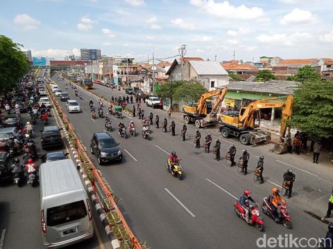 Sejumlah personel polisi dan Satpol PP menutup Frontage Jalan Wonokromo. Penutupan itu dilakukan untuk mengeksekusi rumah milik warga.