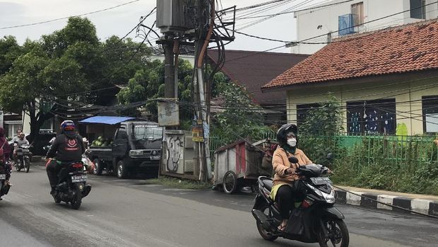 Tiang makan jalan dan kabel smerawut di Jl WR Supratman, tapatnya di dekat SDN Pondok Ranji 01.