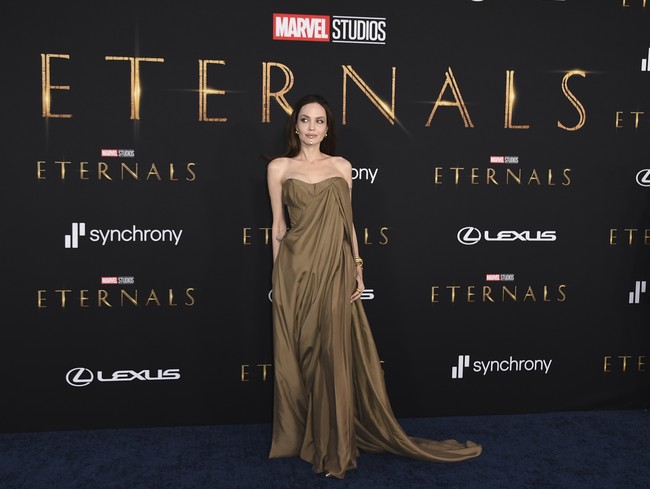 Gaun tersebut hadir dengan model strapless yang mengekspos tato di bahunya. Sementara itu, potongan draperi meninggalkan kesan anggun. (Foto: Jordan Strauss/Invision/AP)