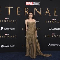 Gaun tersebut hadir dengan model strapless yang mengekspos tato di bahunya. Sementara itu, potongan draperi meninggalkan kesan anggun. (Foto: Jordan Strauss/Invision/AP)