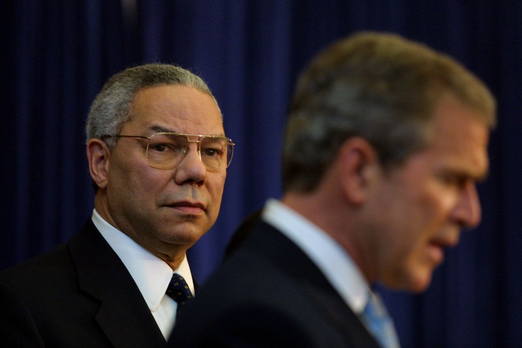 385647 04: President George W. Bush delivers remarks to employees of the State Department as Secretary of State Colin Powell listens February 15, 2001 in Washington, DC. (Pool Photo/Newsmakers)