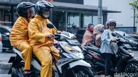 Sebagian besar pemotor mengenakan jas hujan.