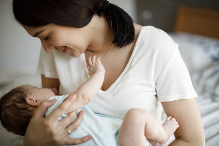 Ilustrasi ibu menyusui atau menggendong bayi