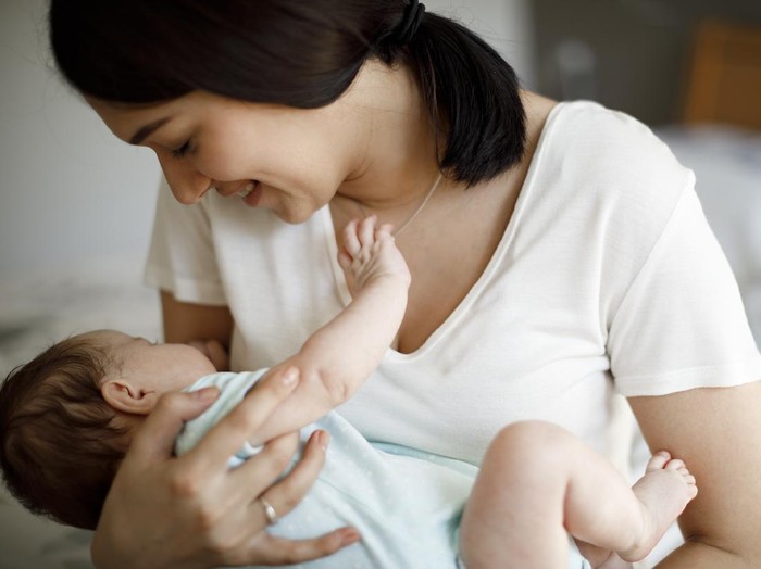 Ilustrasi ibu menyusui atau menggendong bayi
