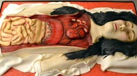 Semakin seram, kue ini dibuat berbentuk organ manusia yang masih menempel di dalam tubuh manusia. Terlihat jantung dan usus di bagian kuenya. Foto: Mental Floss