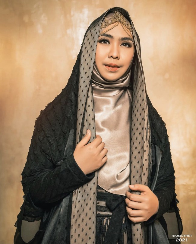 Berbeda dengan kedua adiknya, Oki Setiana Dewi memakai hijab satin warna nude yang senada dengan warna detail veil dress. Dibentuk syari menutupi dada dan juga headpiece yang cantik. Foto: Dok. Instagram @riomotret.