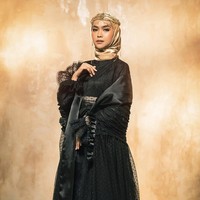 Ria Ricis mengenakan hijab satin gold yang dililit rapi ke belakang sehingga memperlihatkan detail dress yang ia kenakan. Pemakaian headpiece menambah kesan dramatis dan elegan. Foto: Dok. Instagram @riomotret.