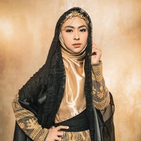 Sama seperti Ria Ricis, hijab yang dikenakan oleh Shindy dari bahan satin. Dan dibentuk syari dilengkapi dengan headpiece dan veil warna hitam. Dalam kesehariannya dokter cantik itu kerap memakai hijab segi empat syari dan gamis. Foto: Dok. Instagram @riomotret.