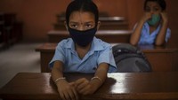 Tampak dua orang siswa mengenakan masker saat akan mengikuti kegiatan belajar di sekolah.