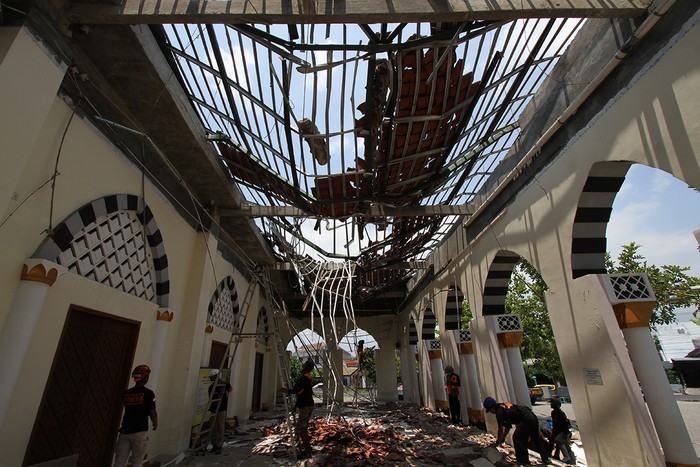 Relawan Independence Rescue Sukoharjo menjatuhkan genting-genting yang dianggap membahayakan usai ambrolnya atap masjid Besar Al Furqon Nguter  jalan Sukoharjo-Wonogiri, Sukoharjo, Jawa Tengah, Rabu (20/10). Atap yang terpasang dari bahan baja ringan tersebut ambrol pukul 06.00 WIB tadi pagi. Beruntung tidak ada korban jiwa dalam peristiwa tersebut. Masjid yang dibangun tahun 2016 tersebut kini tutup sementara untuk dibersihkan dan dalam penyeledikan pihak kepolisian