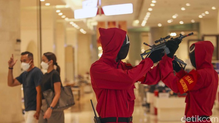 Demam Squid Game Meradang Hingga ke Pusat Perbelanjaan Petugas mengenakan pakaian ala film Squid Game di Lotte Shopping Avenue, Jakarta Selatan. Pakaian ala film Squid Game itu dilakukan guna menarik pengunjung.
