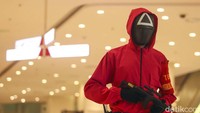 Petugas mengenakan pakaian ala film Squid Game di Lotte Shopping Avenue, Jakarta Selatan, Rabu (20/10/2021).